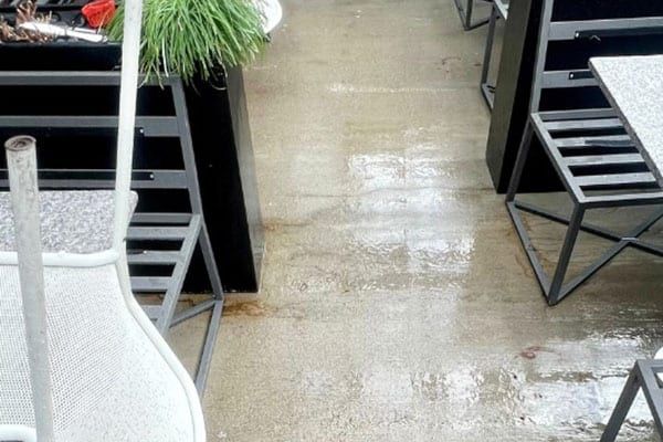 The same patio concrete after pressure washing, pale and even, furniture in place